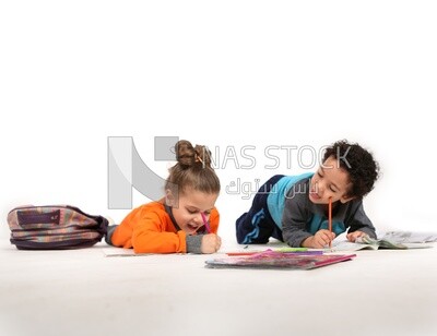 A brother and a sister sitting on the floor studying