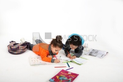 A brother and a sister sitting on the floor studying