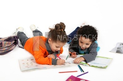 A brother and a sister sitting on the floor studying
