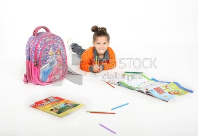 A schoolgirl sitting on the floor and studying