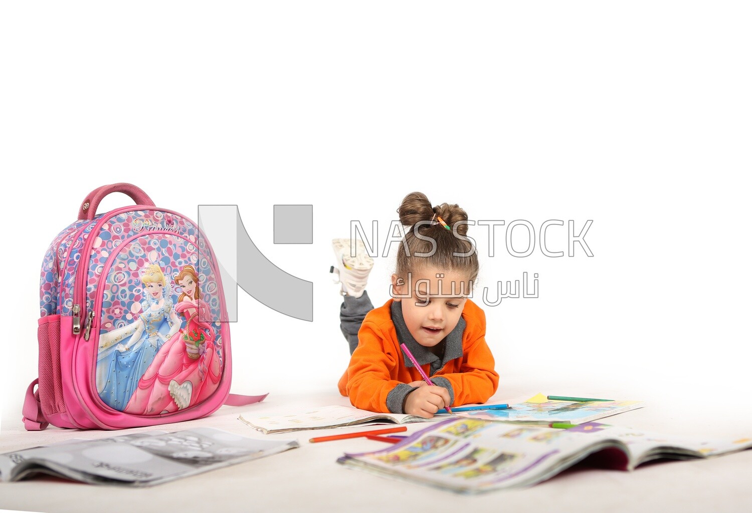 A schoolgirl sitting on the floor and studying