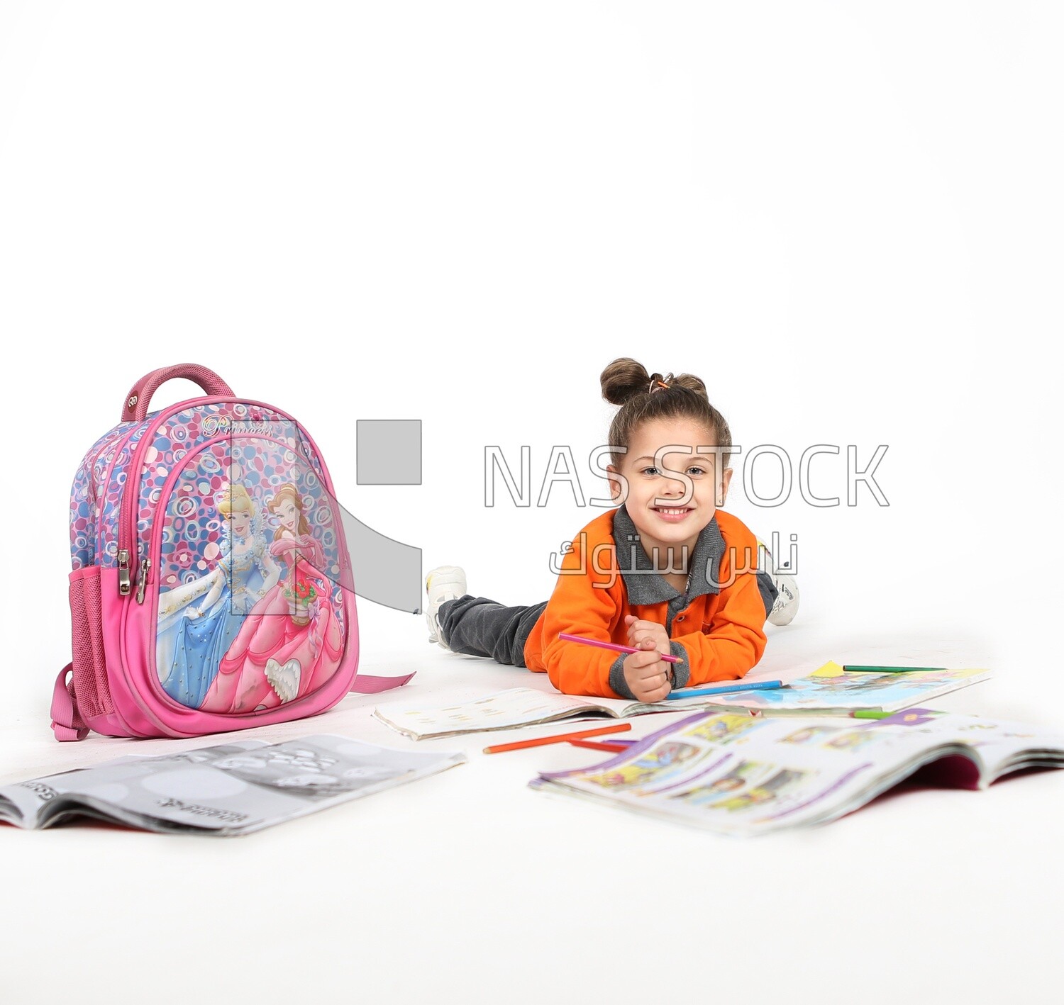 A schoolgirl sitting on the floor and studying