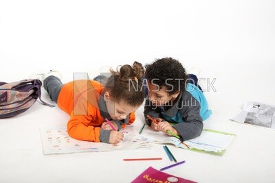 A brother and a sister sitting on the floor studying