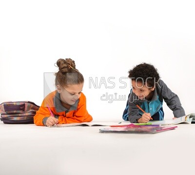 A brother and a sister sitting on the floor studying