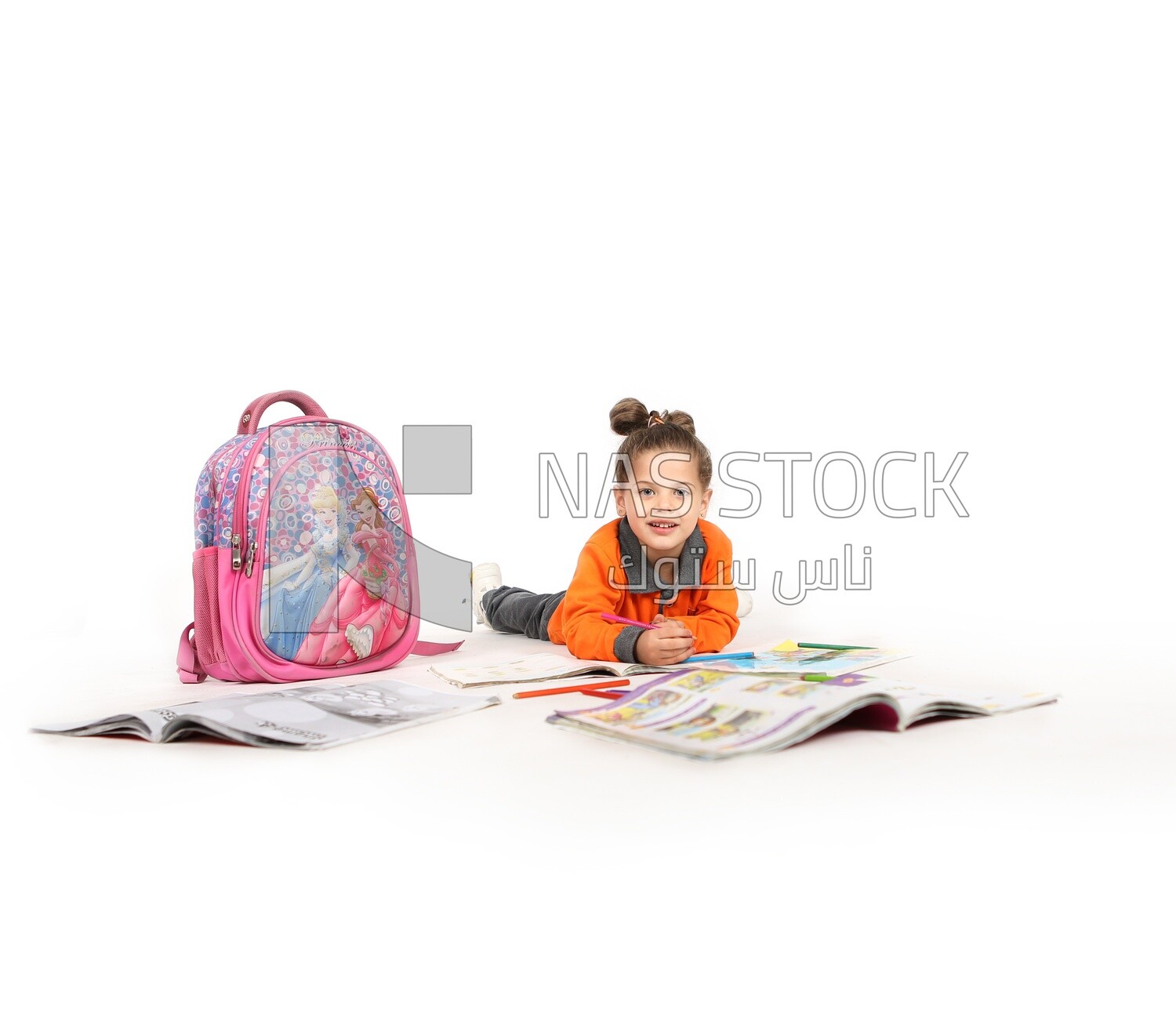 A schoolgirl sitting on the floor and studying