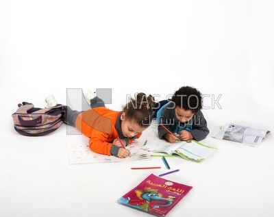 A brother and a sister sitting on the floor studying