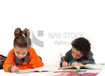 A brother and a sister sitting on the floor studying