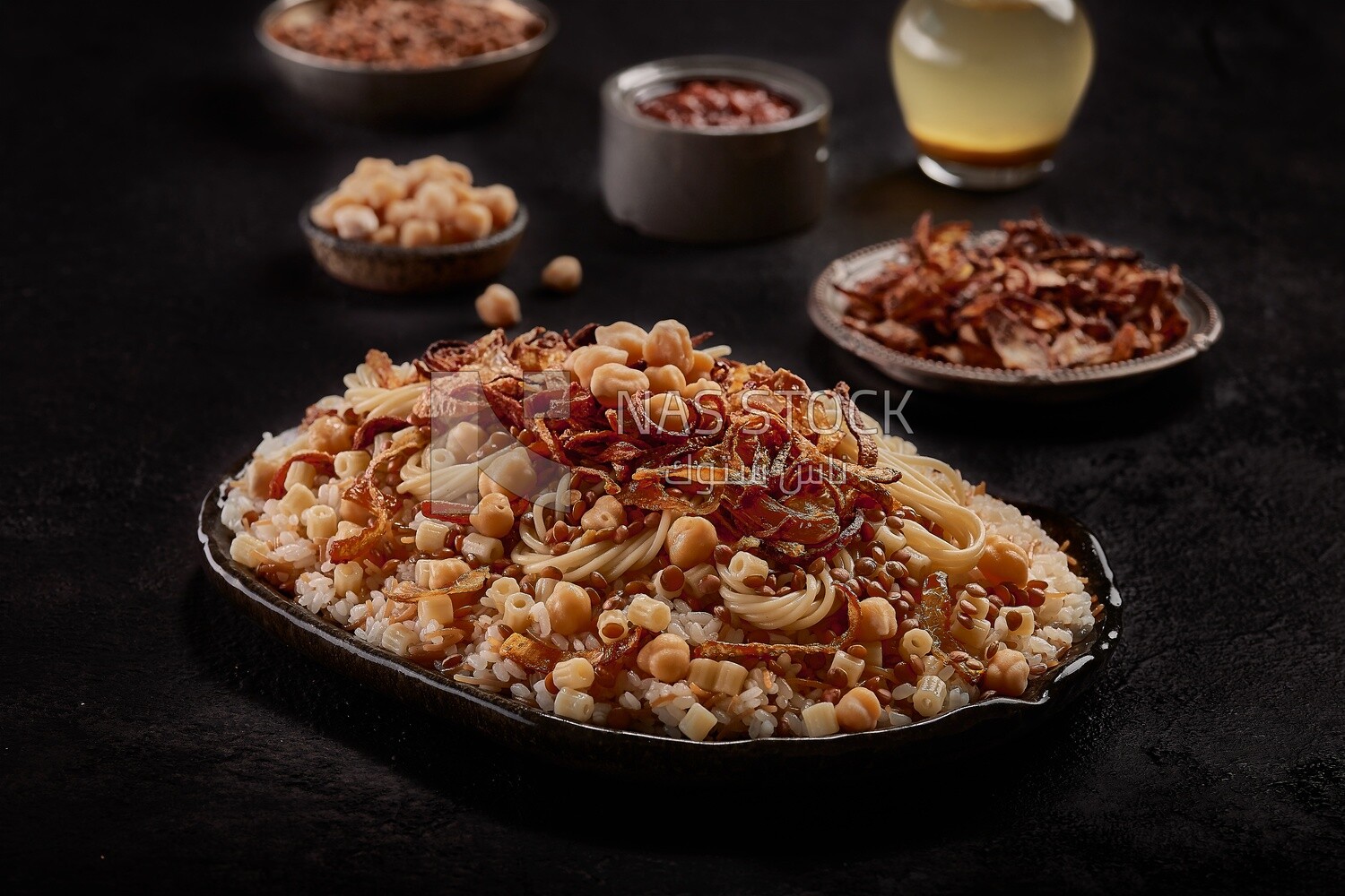 Egyptian Koshary dish with dishes of lentils and fried onions