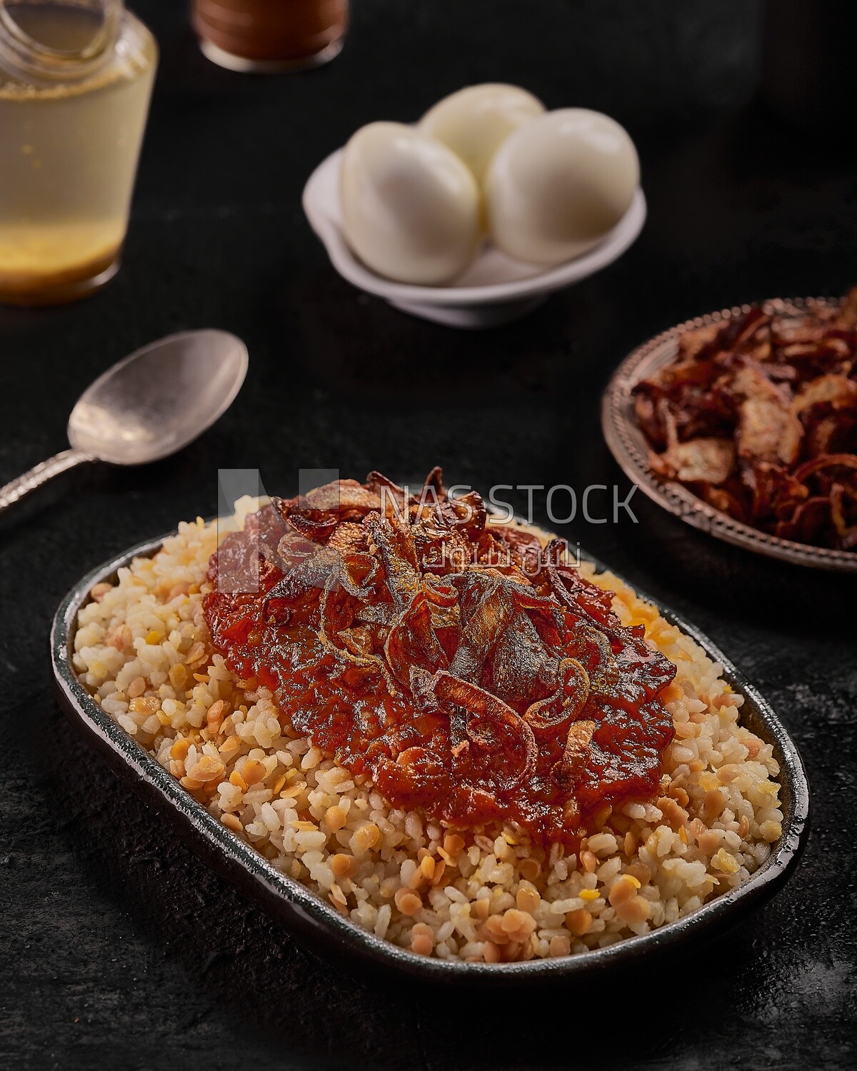 Dining table with an Alexandrian Koshari dish with red sauce