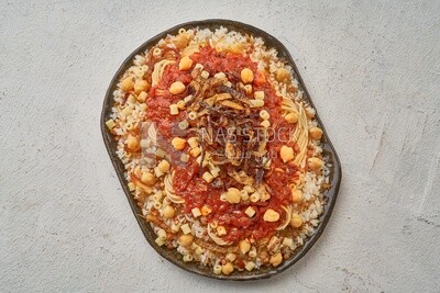 Egyptian Koshary dish with red sauce  on a solid  background
