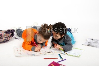 A brother and a sister sitting on the floor studying