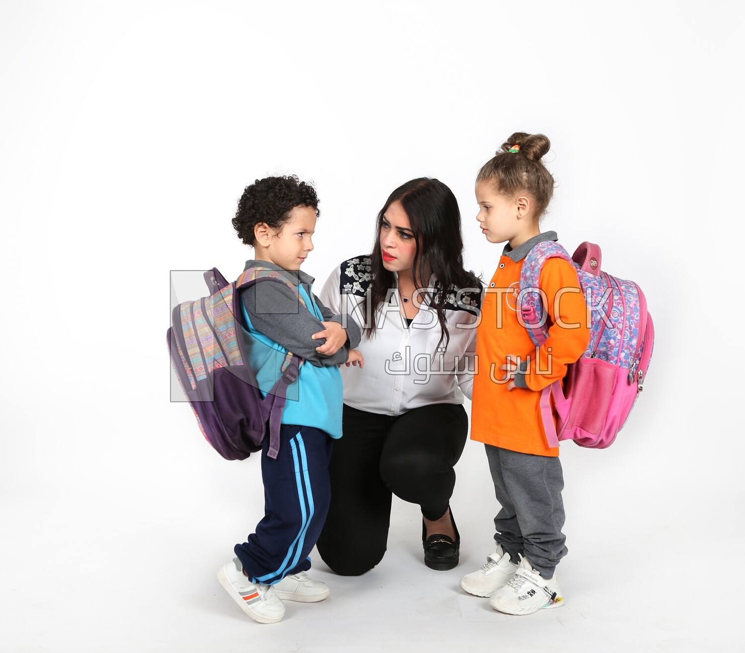 A mother sitting with her kids on a white background