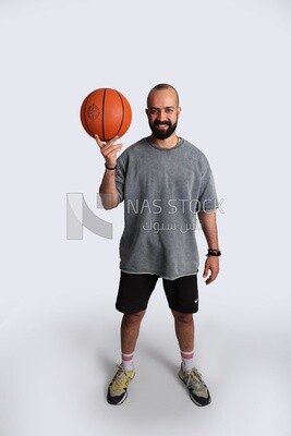 young man wearing sportswear and holding a basketball