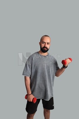 Athletic young man holding dumbbells