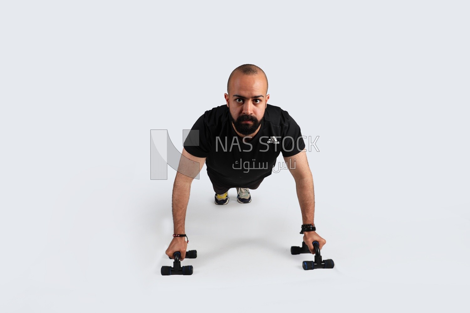 sportsman doing push ups with gym equipment