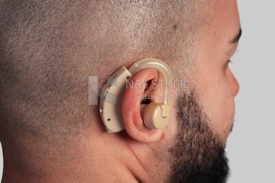 Close up of a hearing aid installed in a man&#39;s ear