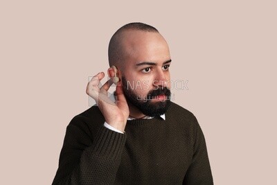 Picture of a hard of hearing man installing a hearing aid in his ear