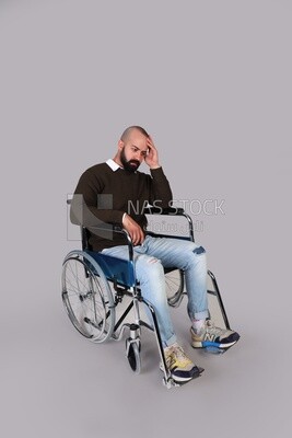 Disabled man in a wheelchair, desperate and sad