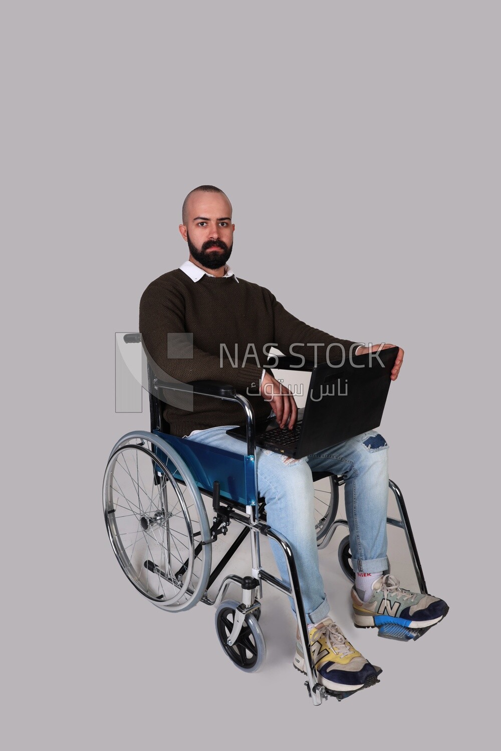 Disabled man in a wheelchair working on a laptop