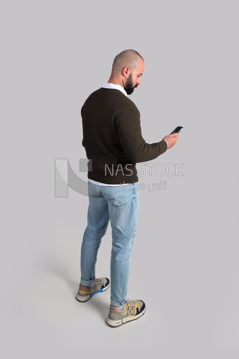 man with a beard looking at his phone