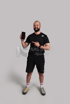 شاب يرتدى ملابس رياضية ويحمل هاتف ذكى