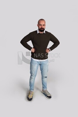 رجل يرتدي كنزة صوفية ويقف متزمراً