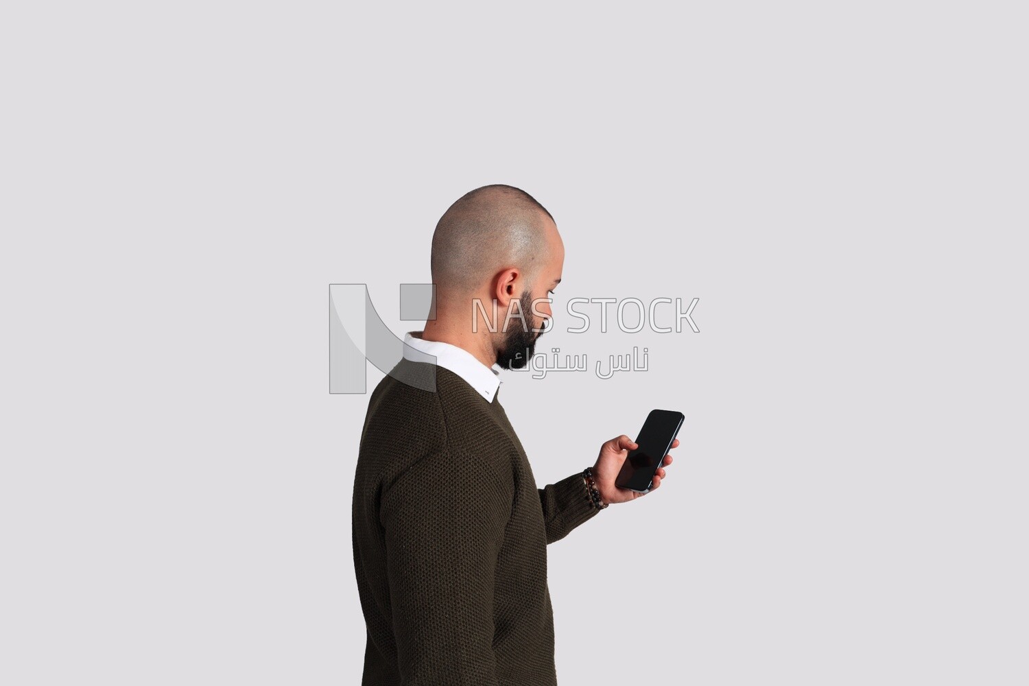 Young man holding a closed phone