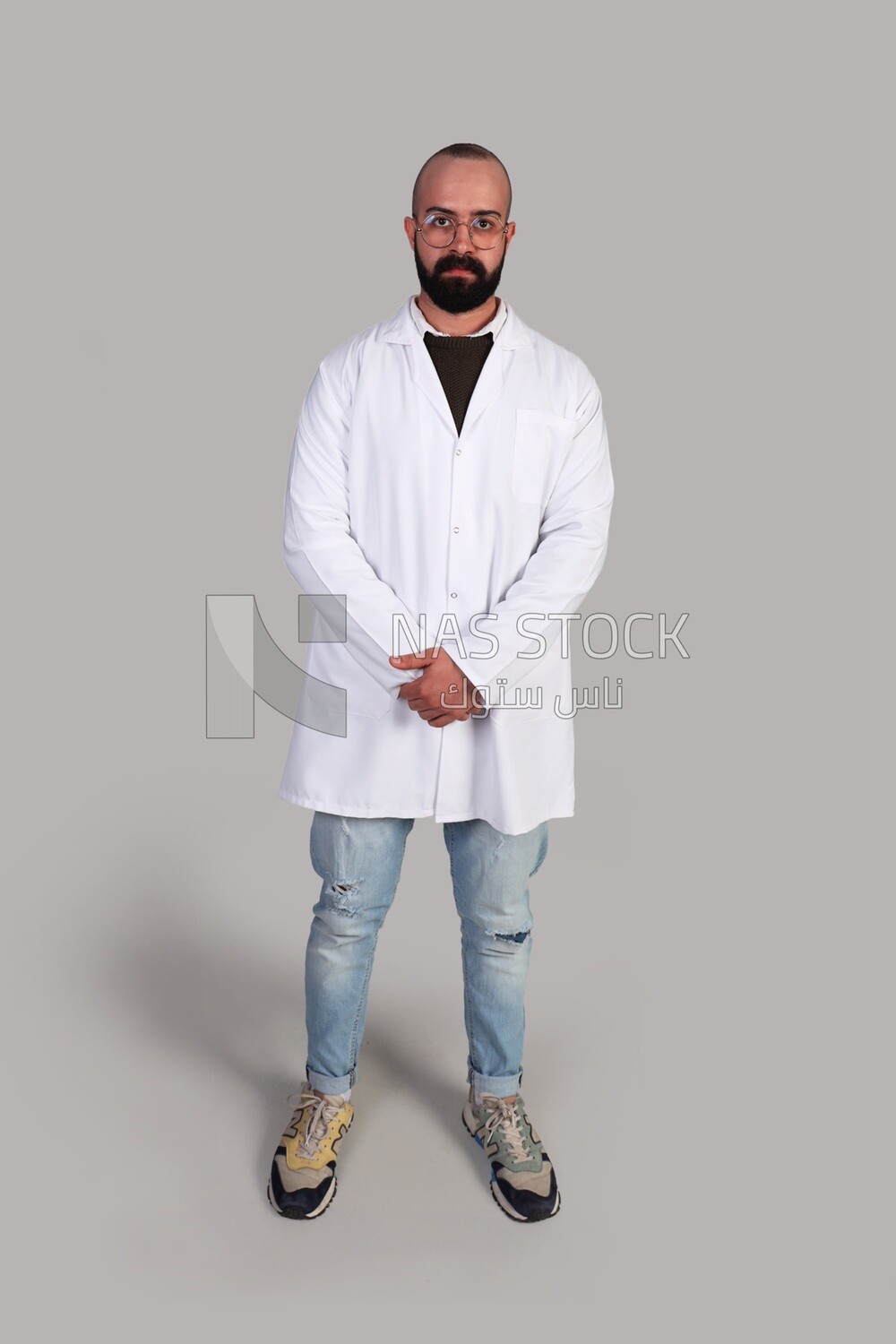 doctor with glasses standing and wearing a hospital uniform