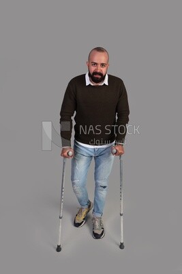 man trying to walk on crutches