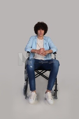 disabled young man with thick curly hair sitting in a wheelchair