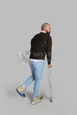 Young man leaning on a crutch