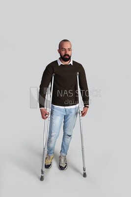 Young man leaning on a crutch