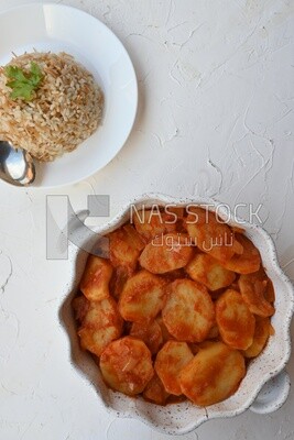 Potato tray sits beside a plate of rice