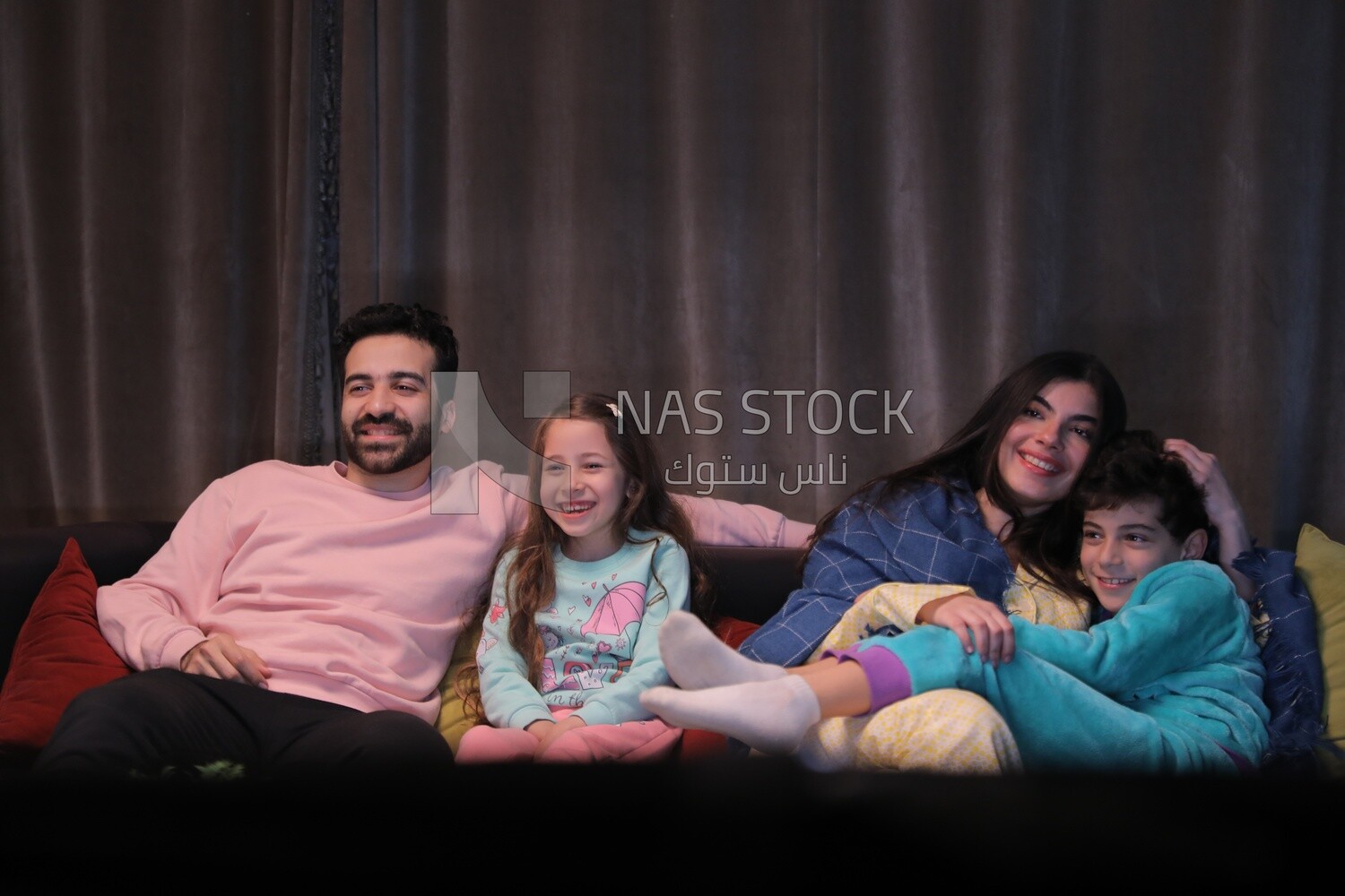 a family of four watching television