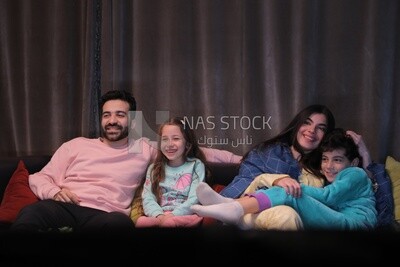 a family of four watching television