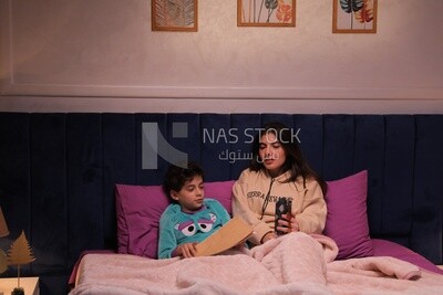 a woman reading a story to her son in bed