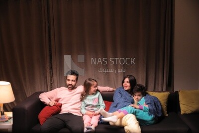 a family of four watching television