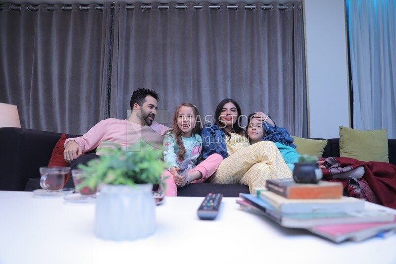 a family of four watching television