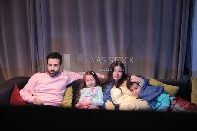 a family of four watching television