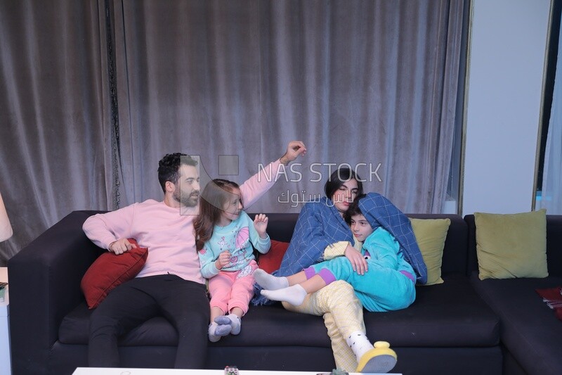 a family of four watching television