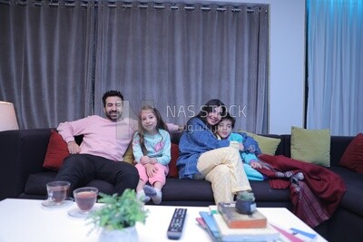 a family of four watching television