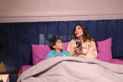 a woman reading a story to her son in bed