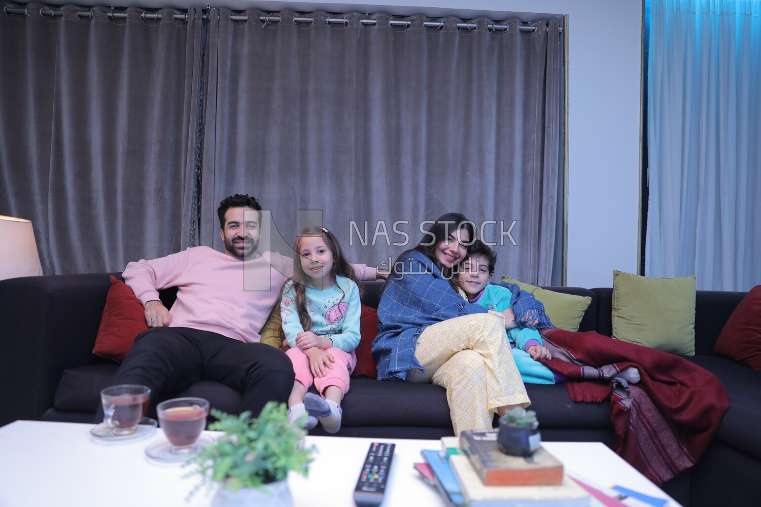 a family of four watching television