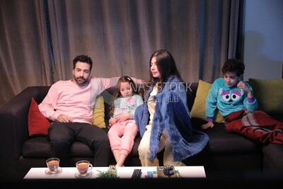 a family of four watching television