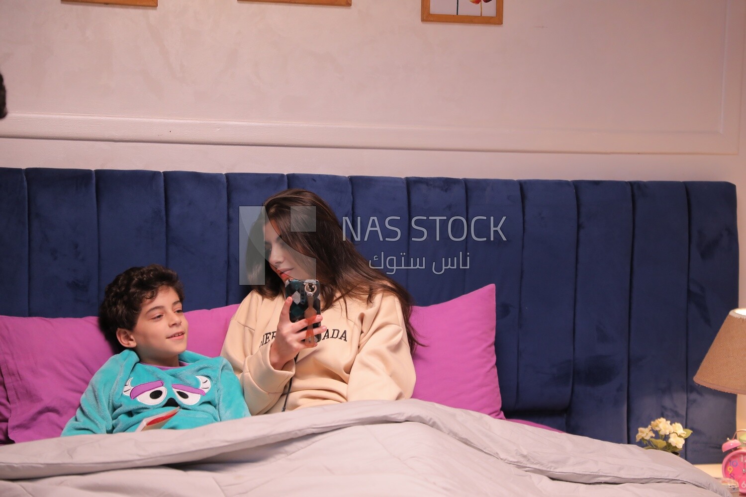 a woman reading a story to her son in bed