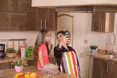 a mother with her girl in the kitchen taking selfie