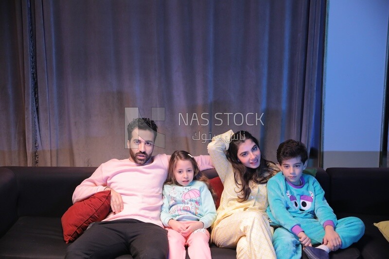 a family of four watching television