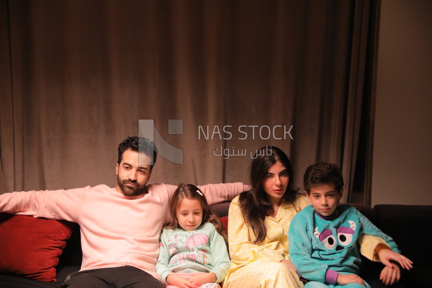 a family of four watching television
