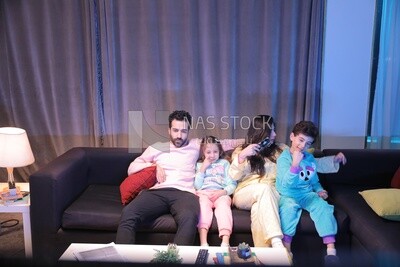 a family of four watching television