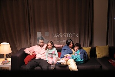 a family of four watching television